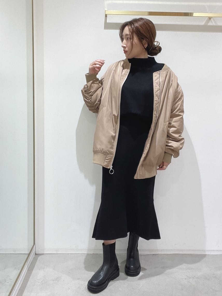 ブラック系のブーツ、ブラック系のニット/セーター、ブラック系のスカートを着用したレディースの秋コーディネートの2枚目の写真