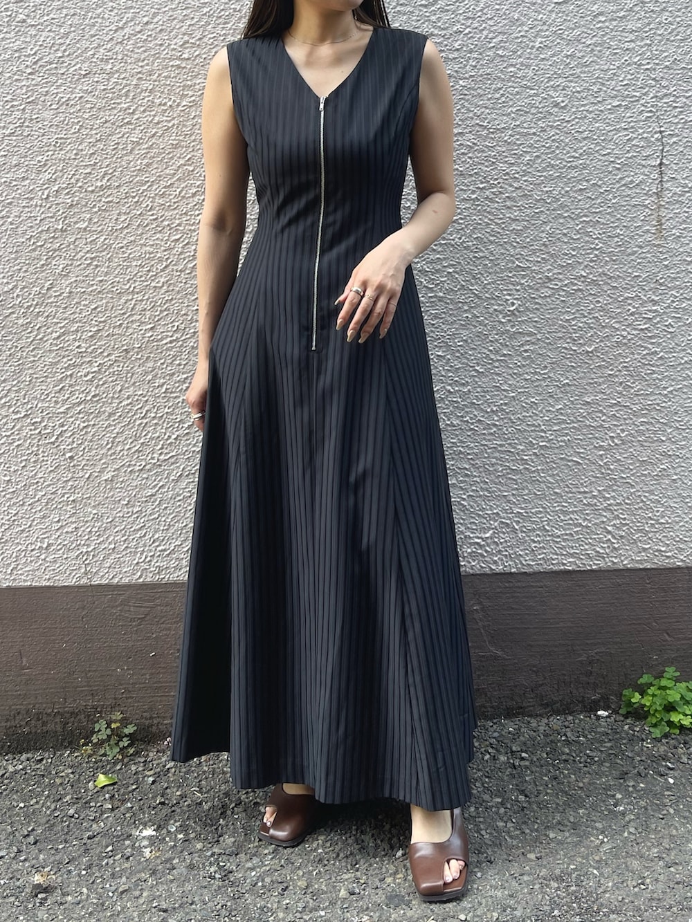 ブラック系のワンピース、ブラウン系のサンダルを着用したレディースの春コーディネートの2枚目の写真