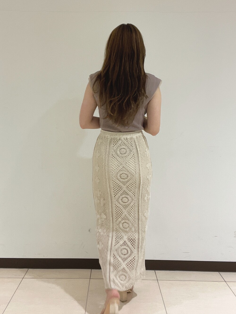 ホワイト系のスカート、ベージュ系のニット/セーターを着用したレディースの夏コーディネートの6枚目の写真