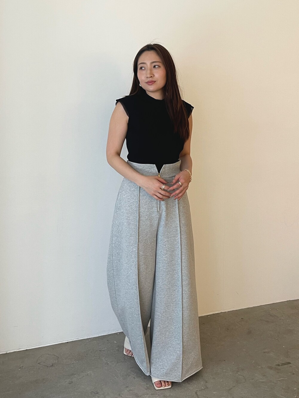 グレー系のスウェットパンツ、ホワイト系のサンダル、ブラック系のニット/セーターを着用したレディースの春コーディネートの3枚目の写真