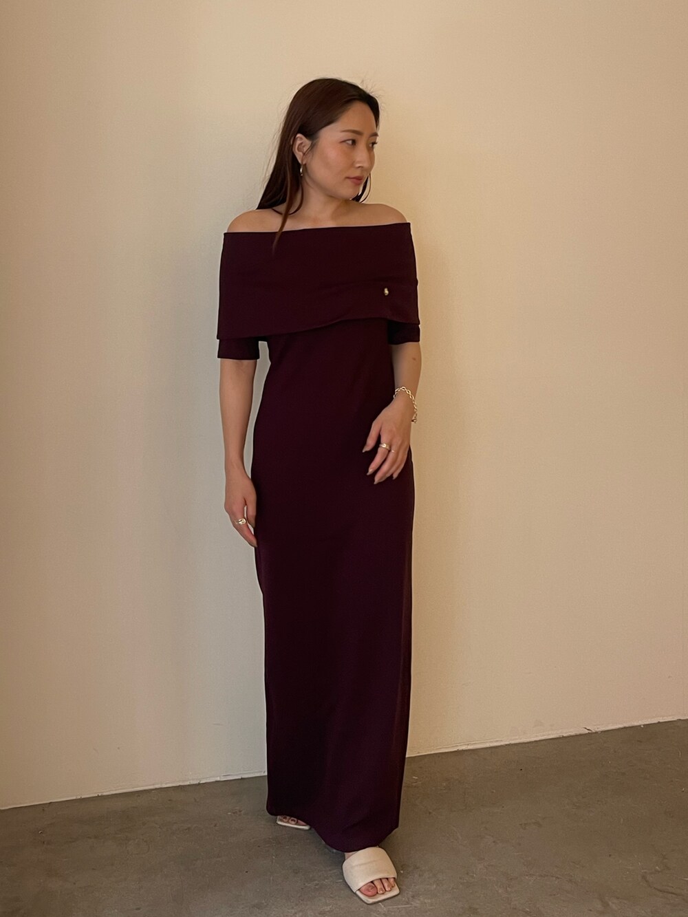 ブラウン系のワンピース、ホワイト系のサンダル、ゴールド系のブレスレットを着用したレディースの春コーディネートの3枚目の写真