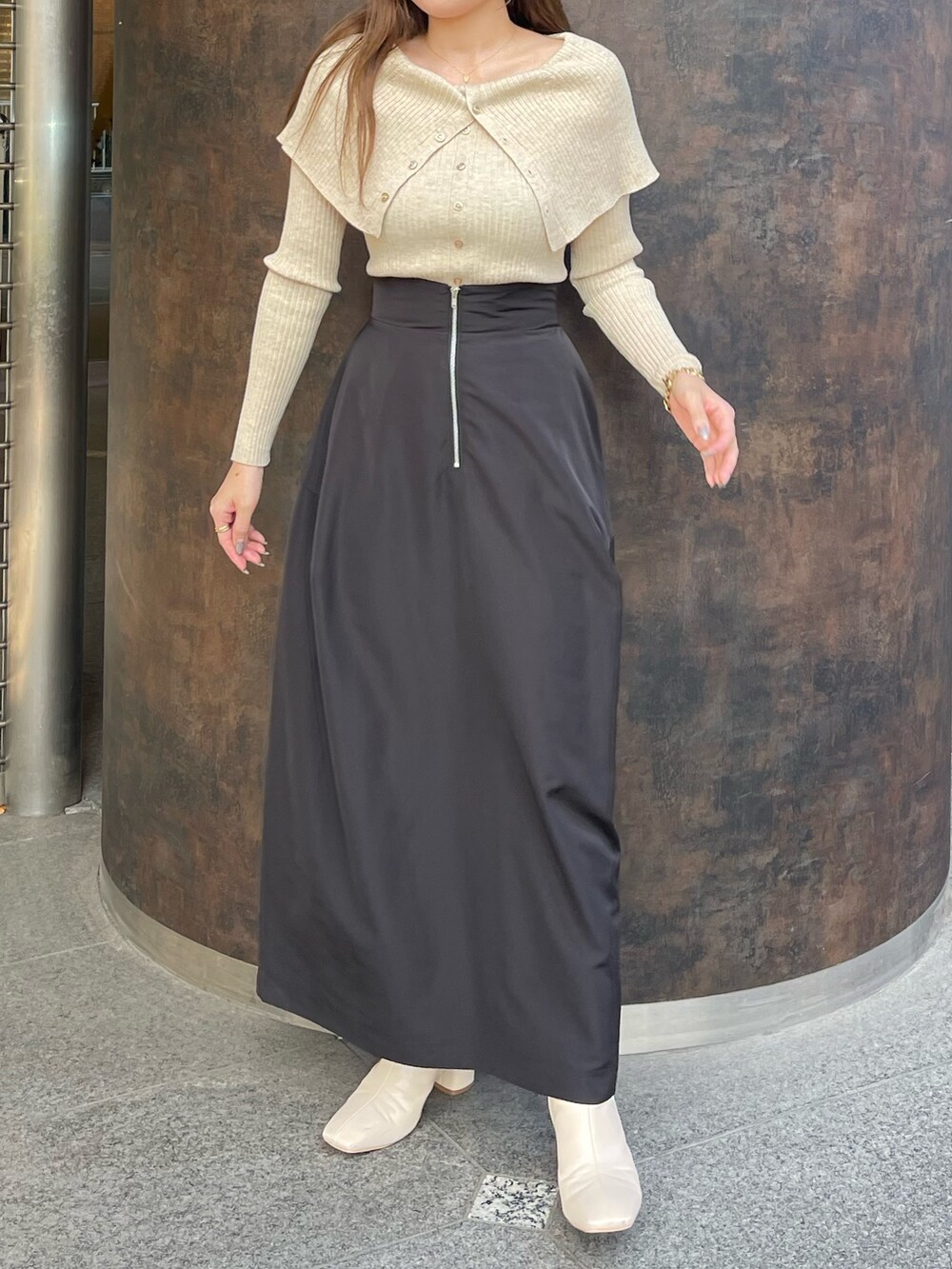 ホワイト系のブーツ、ベージュ系のニット/セーター、ブラック系のスカートを着用したレディースの冬コーディネートの5枚目の写真