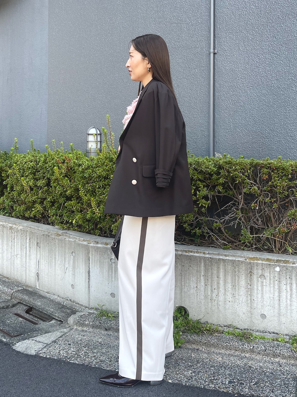 ブラウン系のハンドバッグ、ピンク系のシャツ/ブラウス、ブラック系のパンプスを着用したレディースの冬コーディネートの3枚目の写真