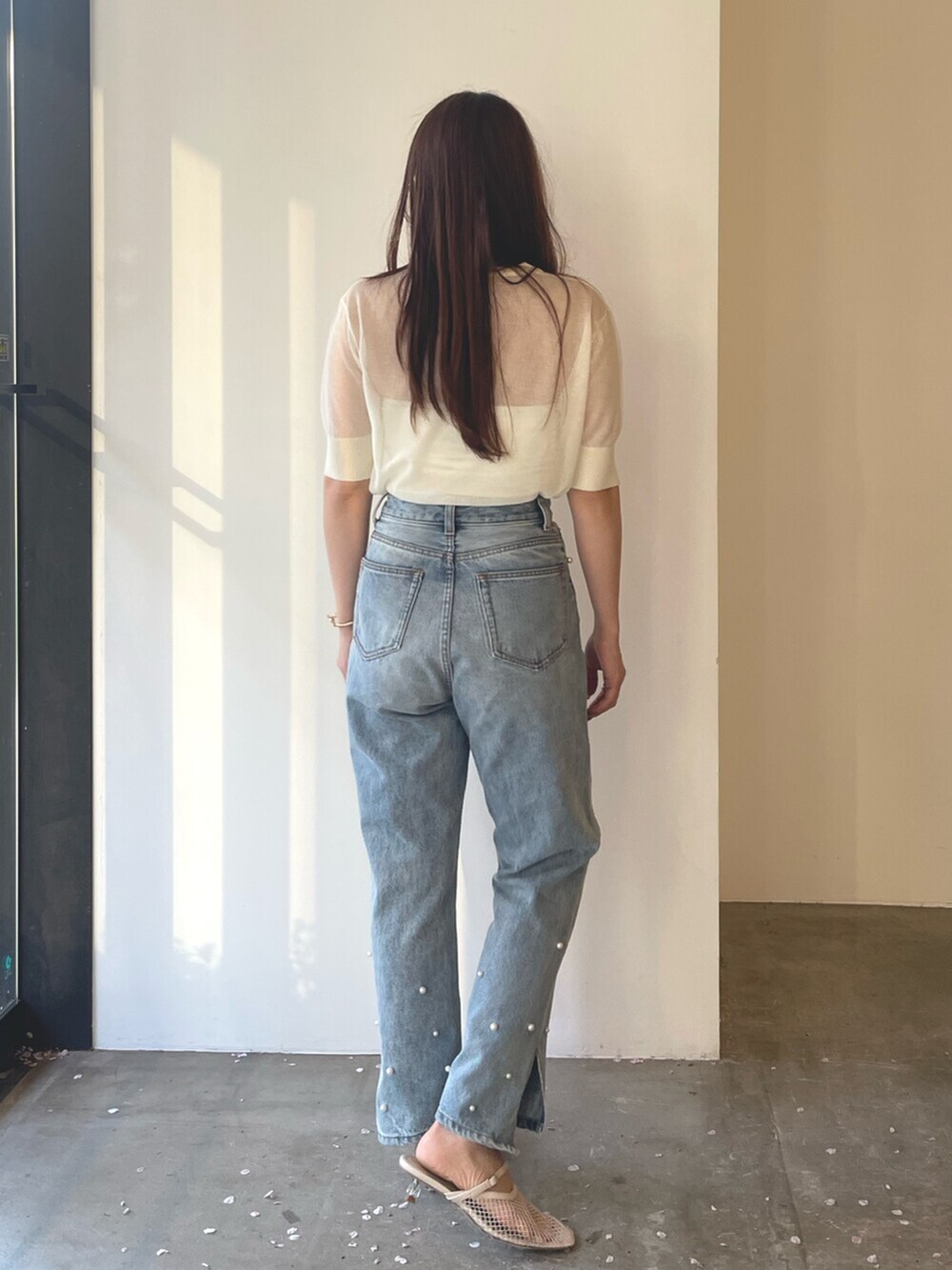 ホワイト系のサンダル、ブルー系のデニムパンツ、ホワイト系のTシャツ/カットソーを着用したレディースの春コーディネートの7枚目の写真