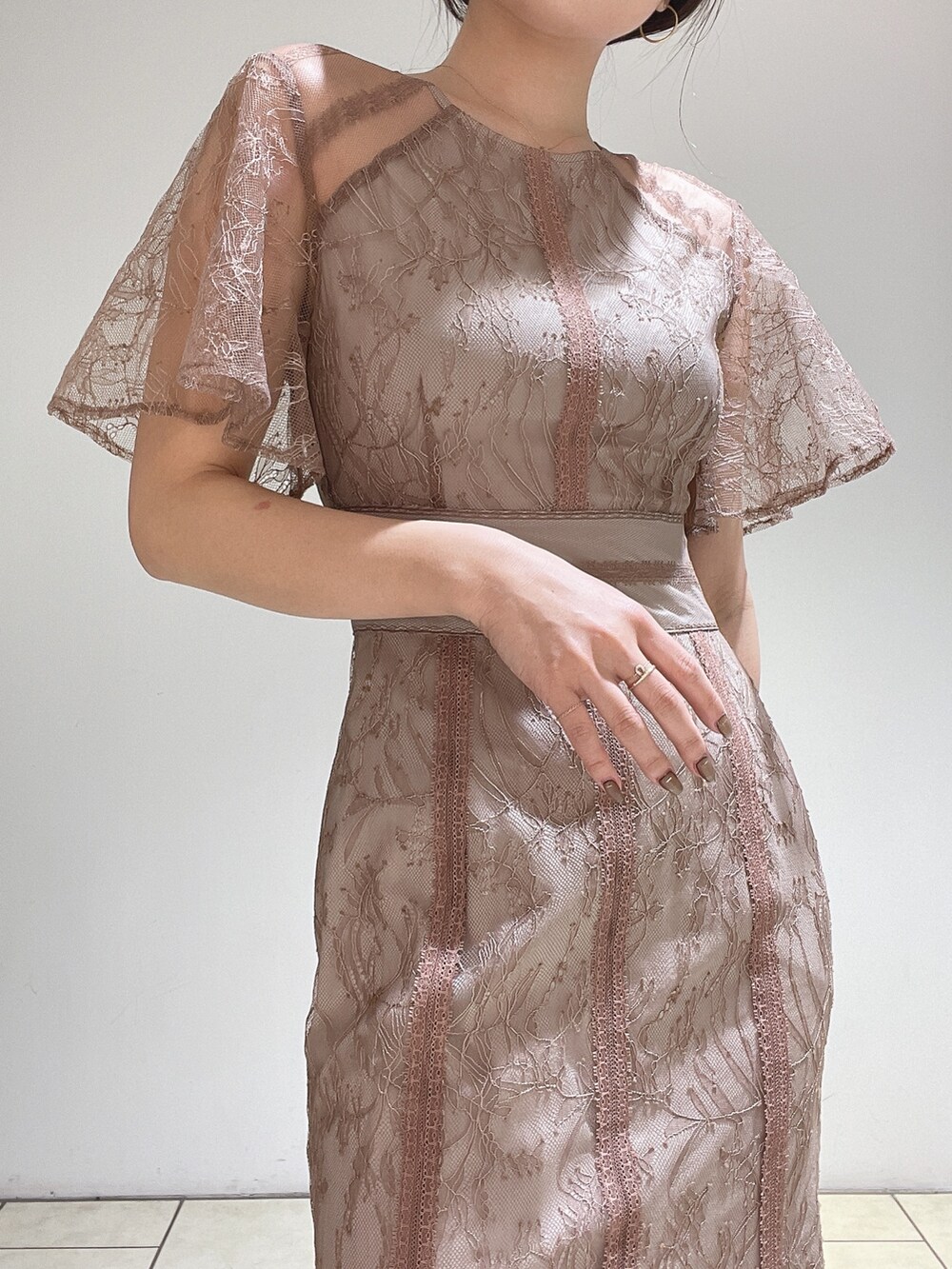 ブラウン系のドレス、ゴールド系のパンプス、ゴールド系のハンドバッグを着用したレディースの冬コーディネートの9枚目の写真