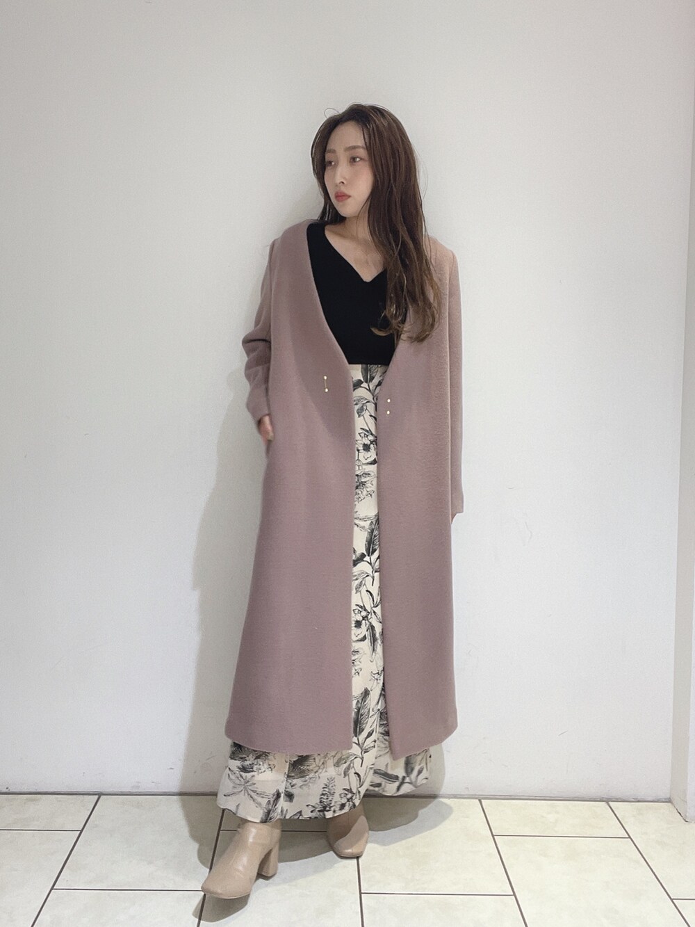 ベージュ系のスカート、ブラック系のニット/セーターを着用したレディースの秋コーディネートの8枚目の写真