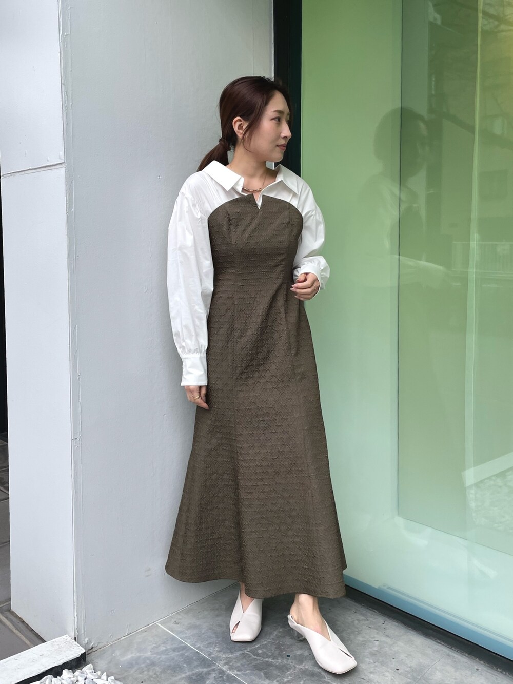 ホワイト系のパンプス、ブラウン系のワンピース、ゴールド系のネックレスを着用したレディースの春コーディネートの2枚目の写真