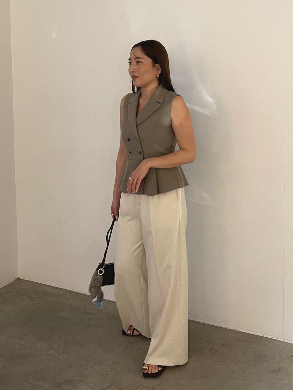 ブラウン系のサンダル、ブラウン系のベスト、ホワイト系のその他パンツを着用したレディースの春コーディネートの4枚目の写真