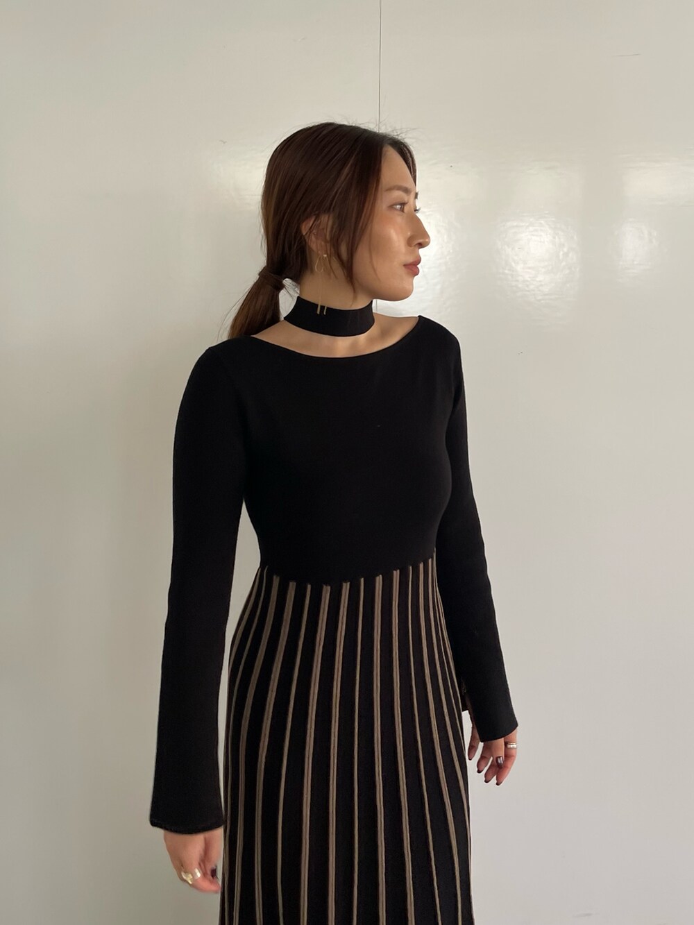 ブラック系のワンピース、シルバー系のブーツを着用したレディースの冬コーディネートの5枚目の写真