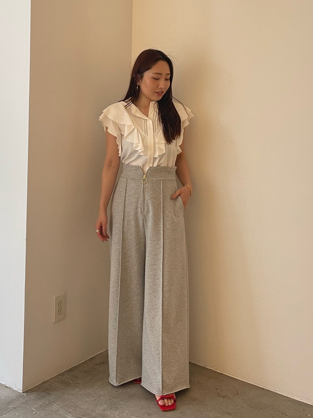 レッド系のサンダル、ホワイト系のシャツ/ブラウス、グレー系のスウェットパンツを着用したレディースの春コーディネートの4枚目の写真