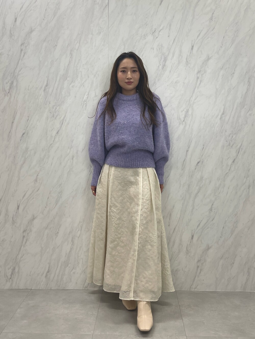 ホワイト系のスカート、ホワイト系のブーツ、パープル系のニット/セーターを着用したレディースの冬コーディネートの5枚目の写真