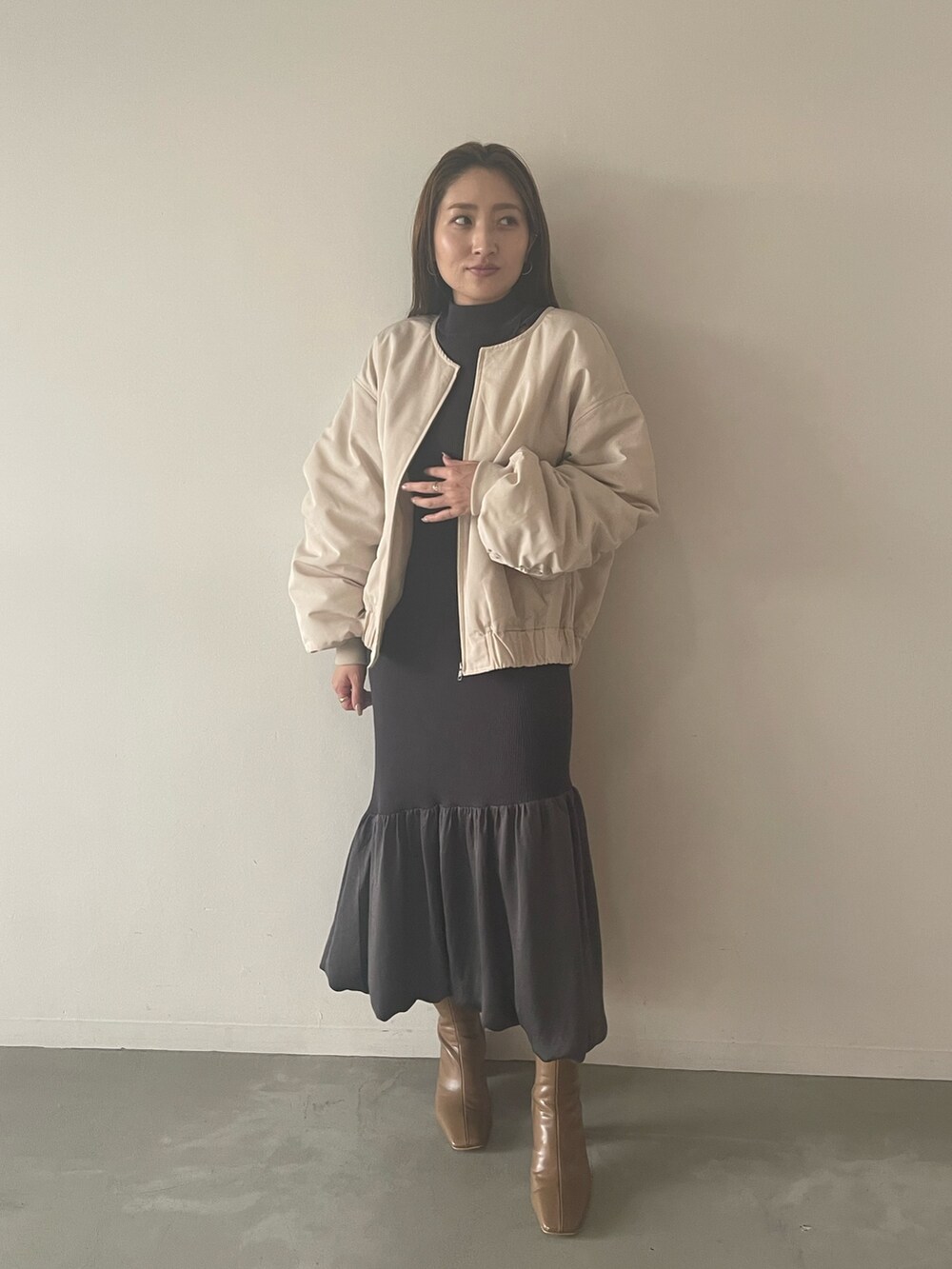 グレー系のワンピース、ベージュ系のブーツ、ホワイト系のブルゾンを着用したレディースの夏コーディネートの6枚目の写真