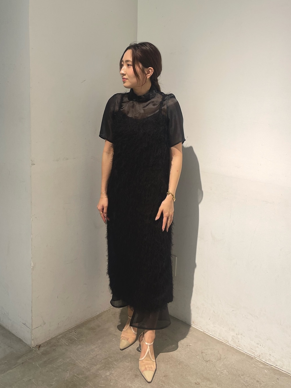 ベージュ系のパンプス、ブラック系のドレスを着用したレディースの春コーディネートの2枚目の写真