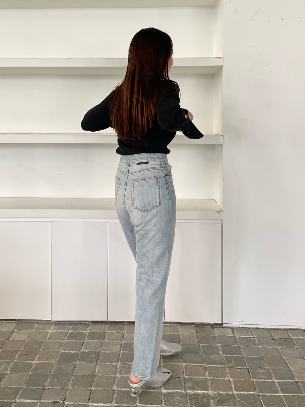 ブルー系のデニムパンツ、ブラック系のニット/セーターを着用したレディースの冬コーディネートの5枚目の写真