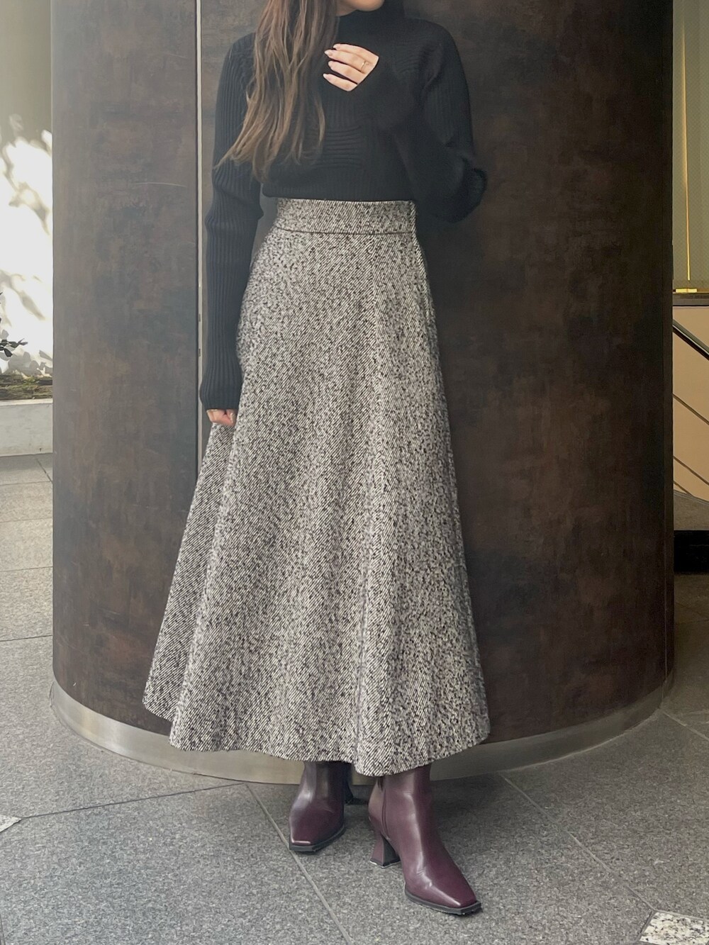 ブラック系のスカート、レッド系のブーツを着用したレディースの秋コーディネートの3枚目の写真