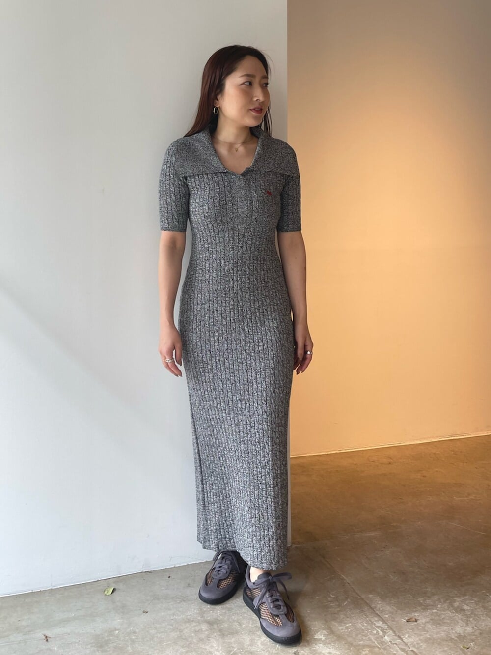 グレー系のスニーカー、ブラック系のワンピースを着用したレディースの春コーディネートの2枚目の写真