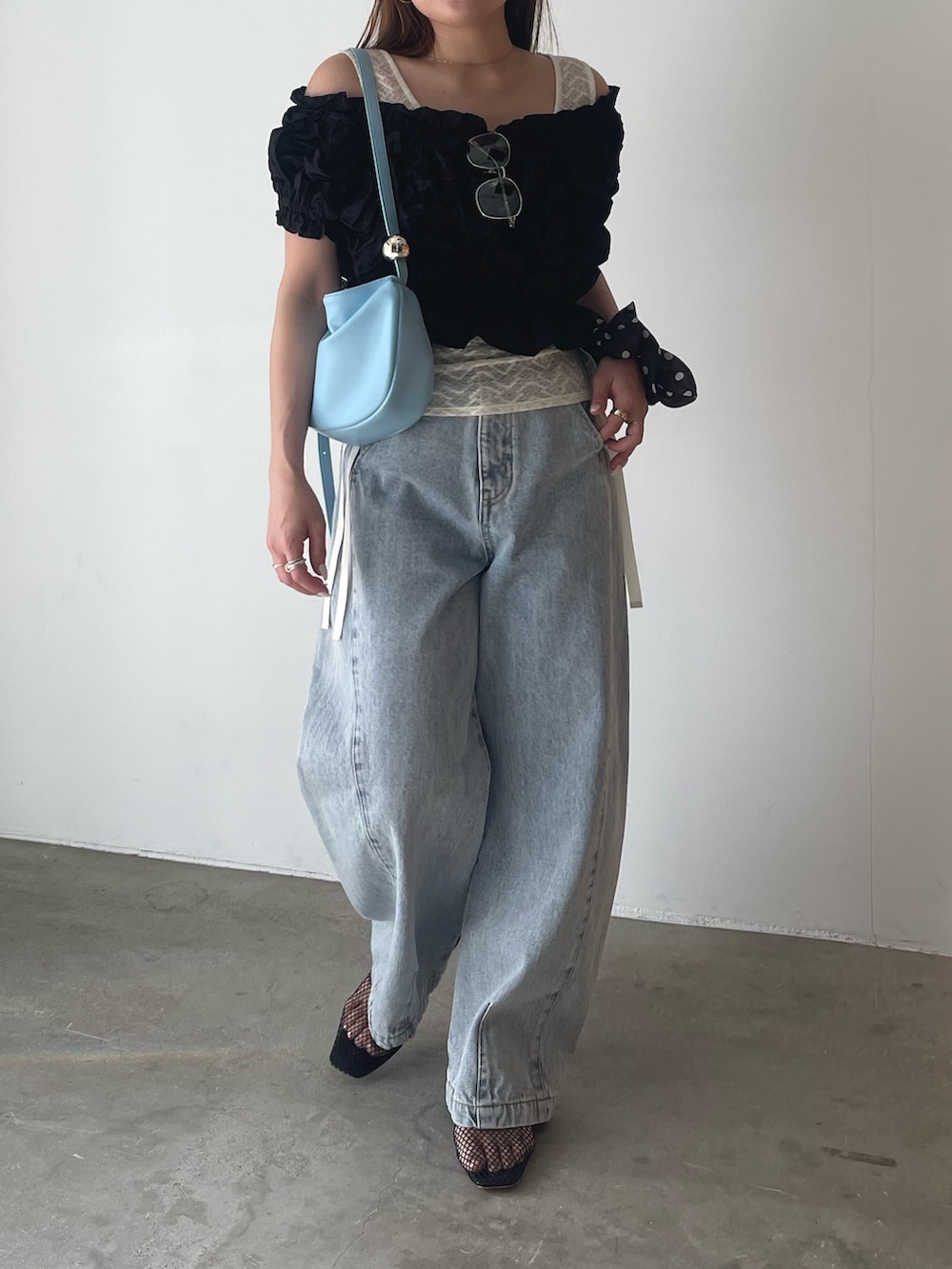 ブラック系のパンツドレス、ブルー系のデニムパンツ、ホワイト系のシャツ/ブラウスを着用したレディースの春コーディネートの3枚目の写真