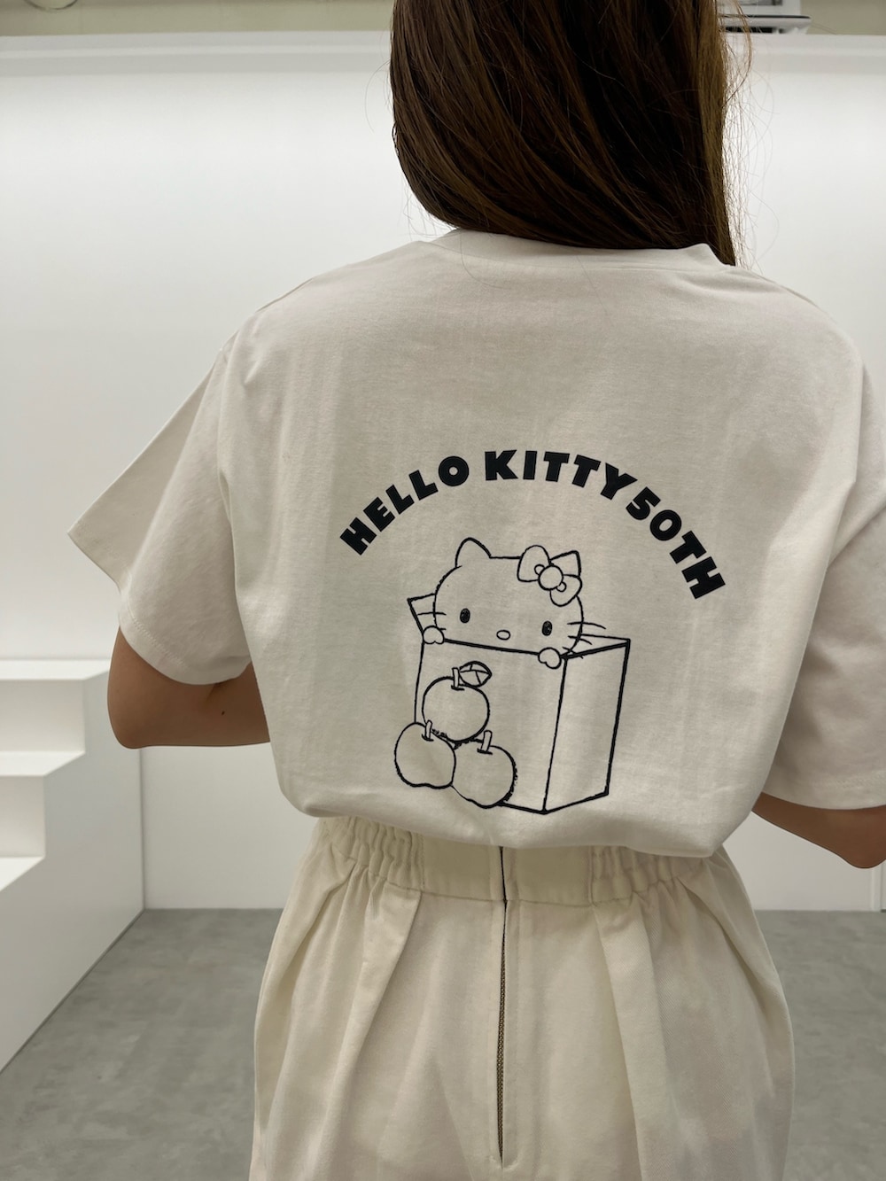 ブラック系のスニーカー、ホワイト系のデニムスカート、ホワイト系のTシャツ/カットソーを着用したレディースの春コーディネートの5枚目の写真