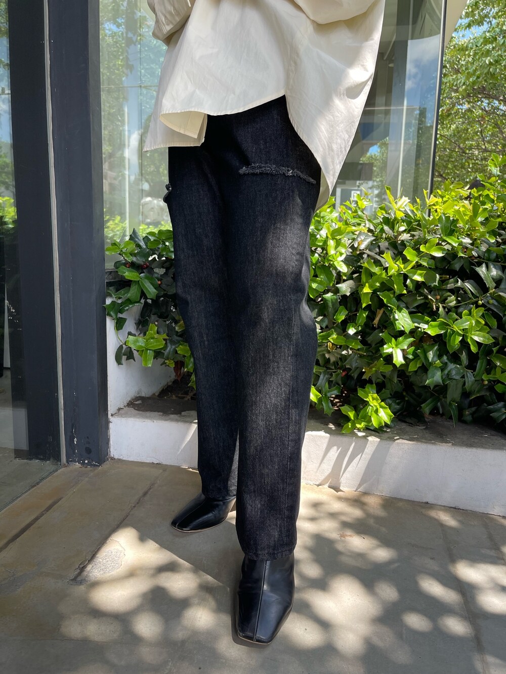 ホワイト系のシャツ/ブラウス、ブラック系のブーツ、ブラック系のデニムパンツを着用したレディースの秋コーディネートの6枚目の写真