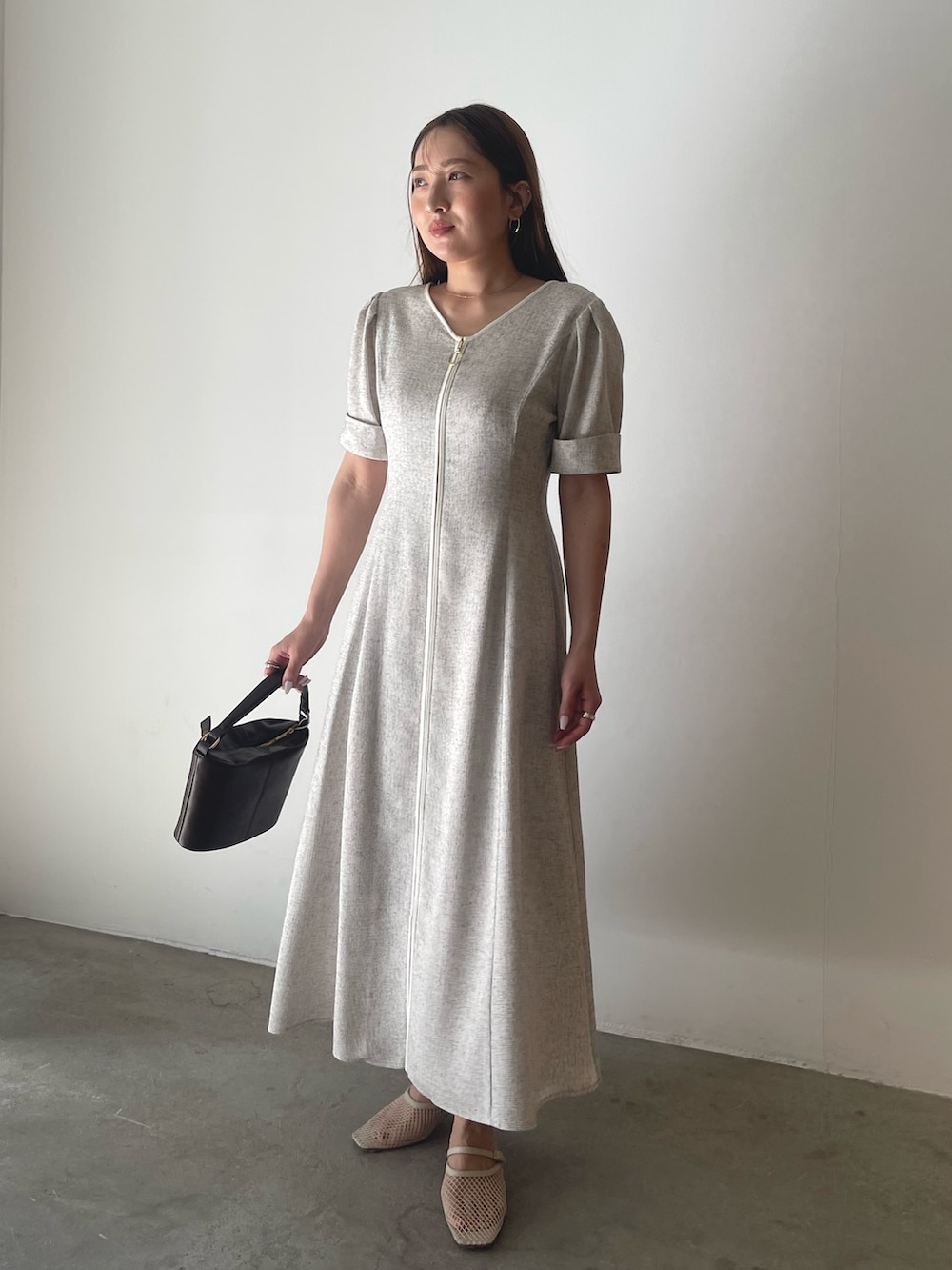 ブラウン系のハンドバッグ、ホワイト系のワンピースを着用したレディースの冬コーディネートの3枚目の写真