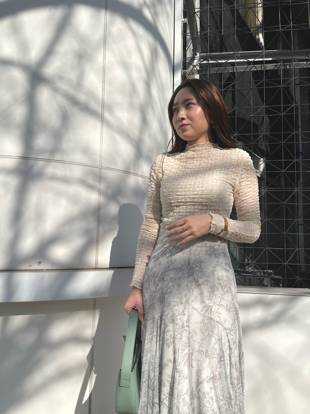 ホワイト系のTシャツ/カットソー、グリーン系のスカート、その他のサンダルを着用したレディースの冬コーディネートの4枚目の写真