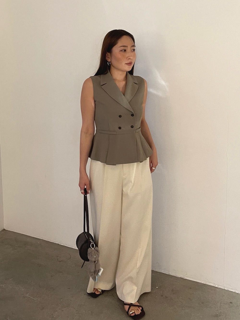 ブラウン系のサンダル、ブラウン系のベスト、ホワイト系のその他パンツを着用したレディースの春コーディネートの6枚目の写真