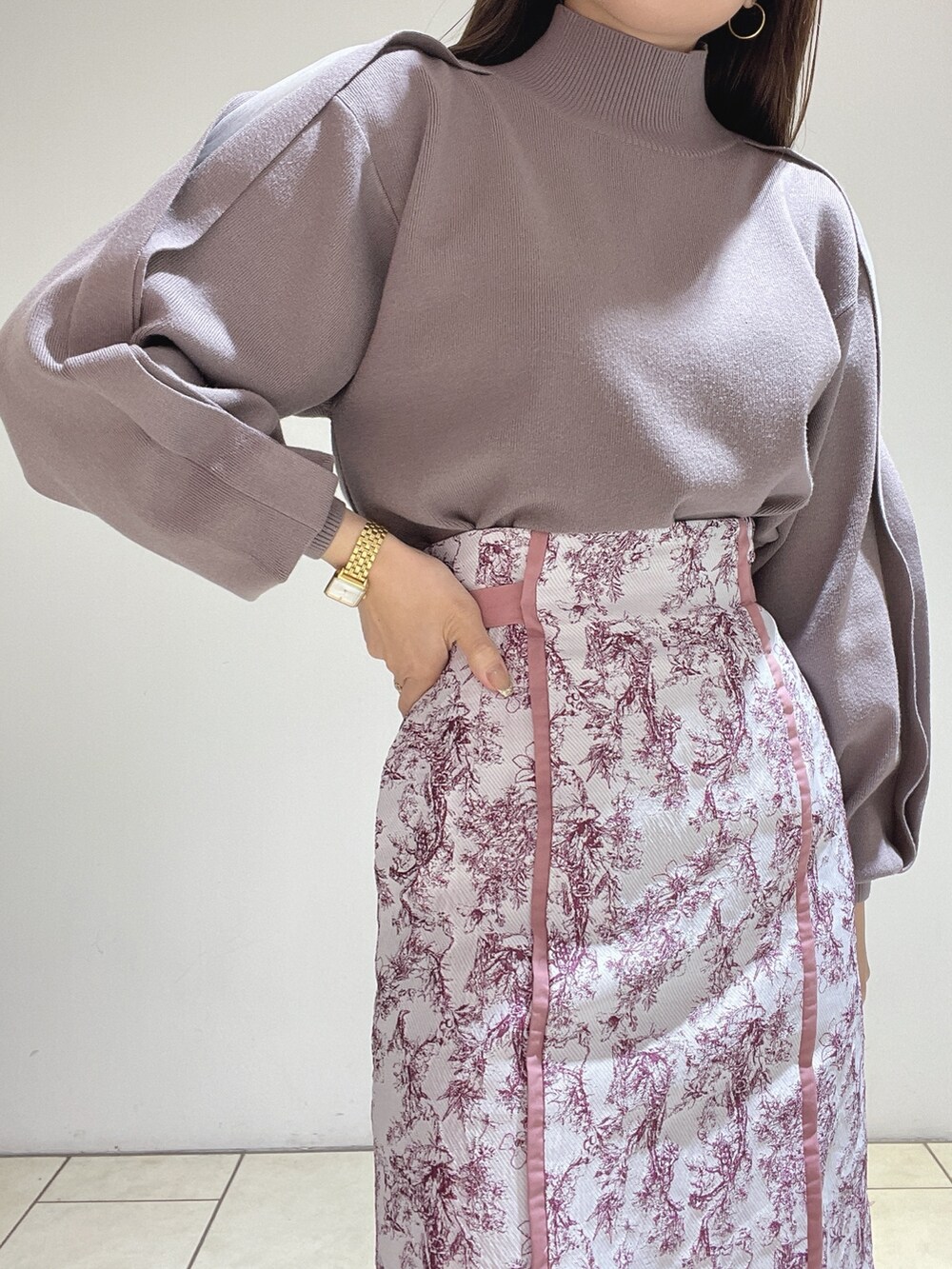 ピンク系のスカート、ブラウン系のニット/セーター、レッド系のブーツを着用したレディースの冬コーディネートの7枚目の写真