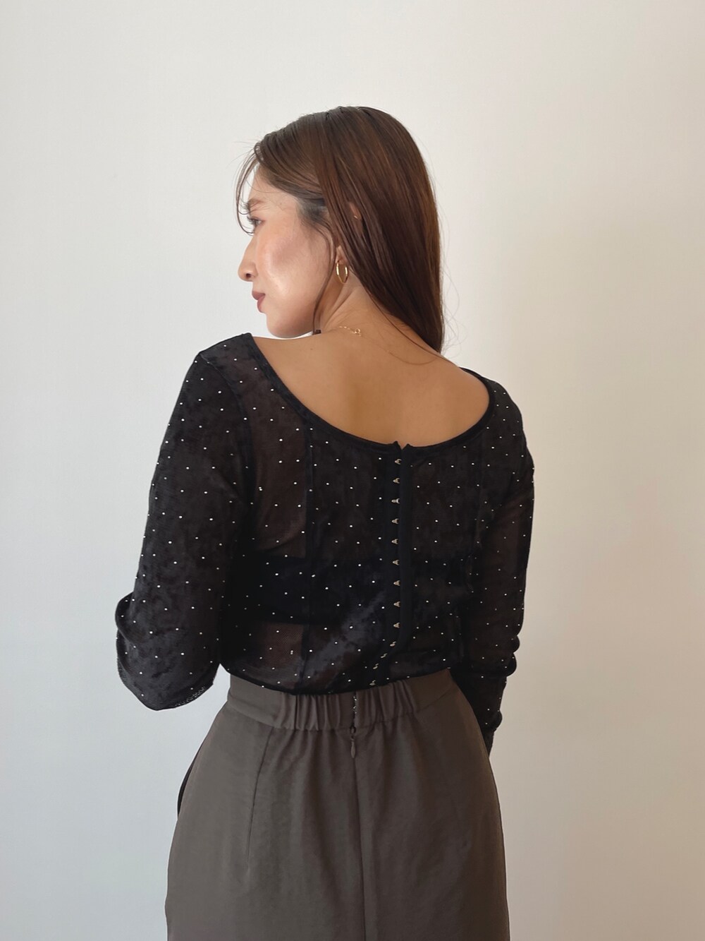 ブラック系のTシャツ/カットソー、ブラウン系のハンドバッグ、ブラウン系のスカートを着用したレディースの秋コーディネートの4枚目の写真