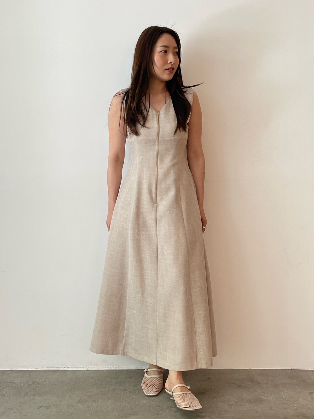 ベージュ系のワンピース、ホワイト系のサンダル、ホワイト系のテーラードジャケットを着用したレディースの夏コーディネートの6枚目の写真