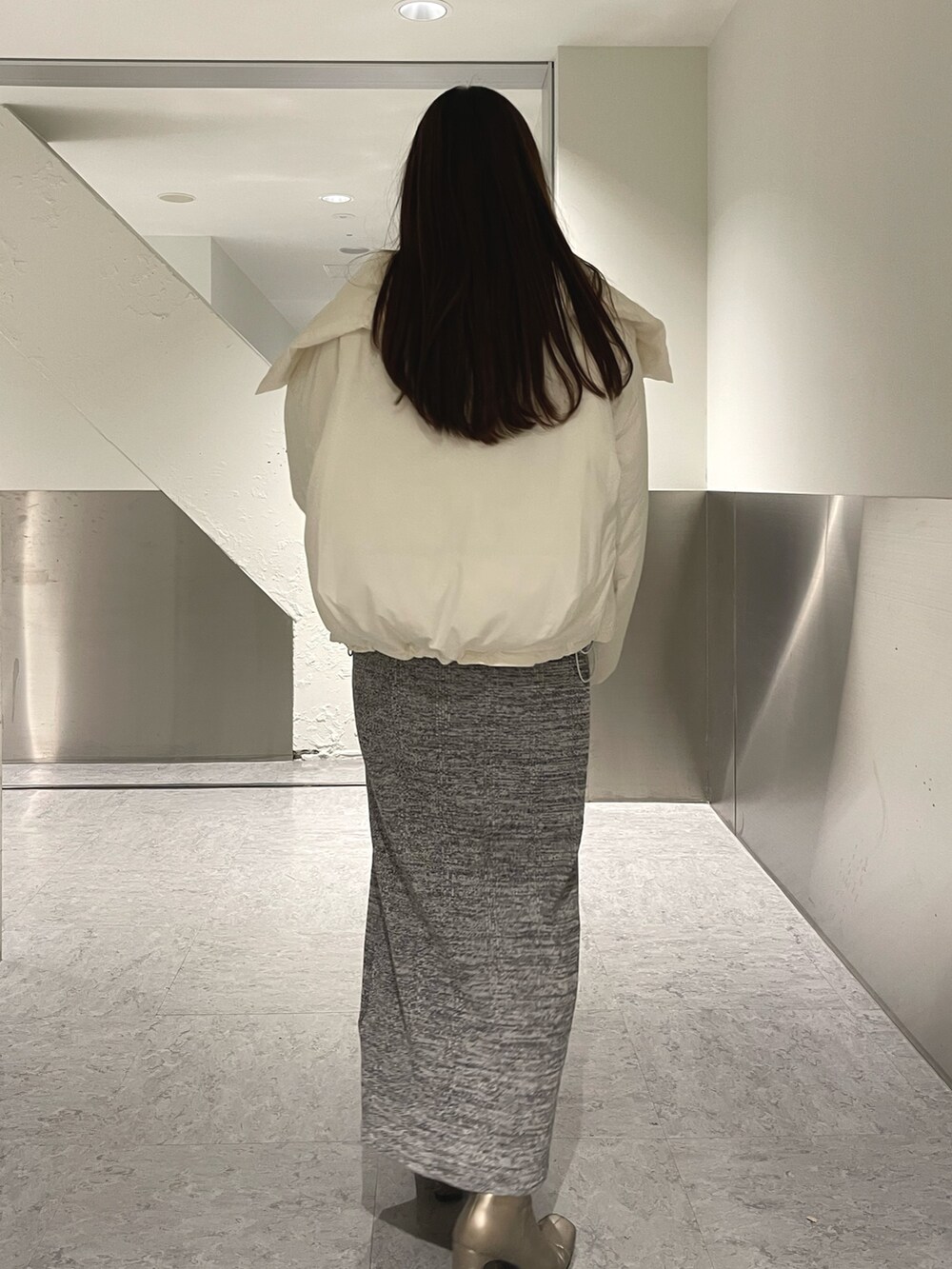 グレー系のワンピース、ホワイト系のダウンジャケット/コートを着用したレディースの冬コーディネートの4枚目の写真