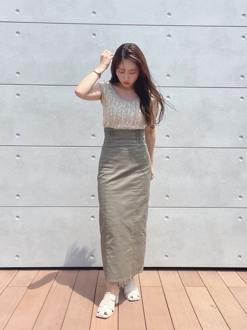 グレー系のスカート、ホワイト系のサンダル、ホワイト系のニット/セーターを着用したレディースの夏コーディネートの4枚目の写真