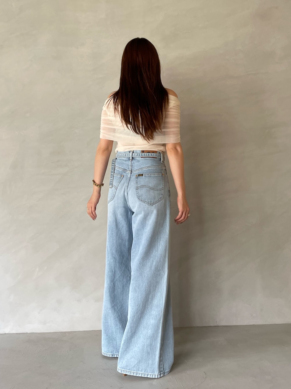 ブルー系のデニムパンツ、ホワイト系のTシャツ/カットソー、ホワイト系のサンダルを着用したレディースの夏コーディネートの7枚目の写真