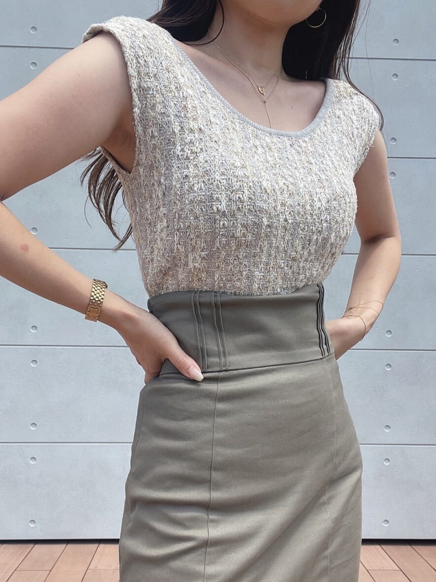 グレー系のスカート、ホワイト系のサンダル、ホワイト系のニット/セーターを着用したレディースの夏コーディネートの2枚目の写真