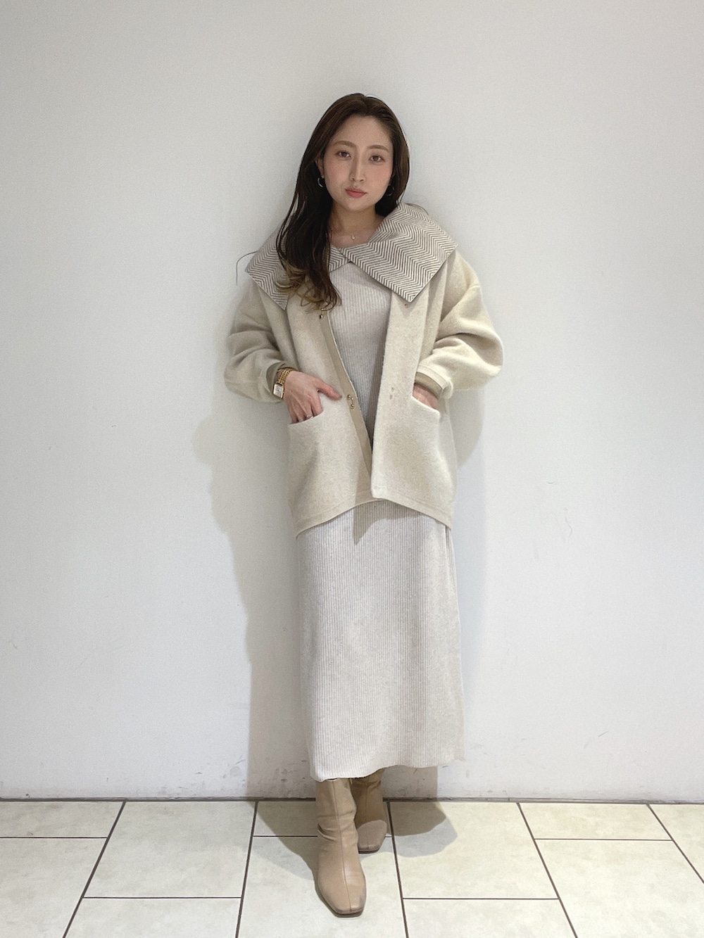 ホワイト系のワンピース、ホワイト系のカーディガン/ボレロ、ベージュ系のブーツを着用したレディースの冬コーディネートの2枚目の写真