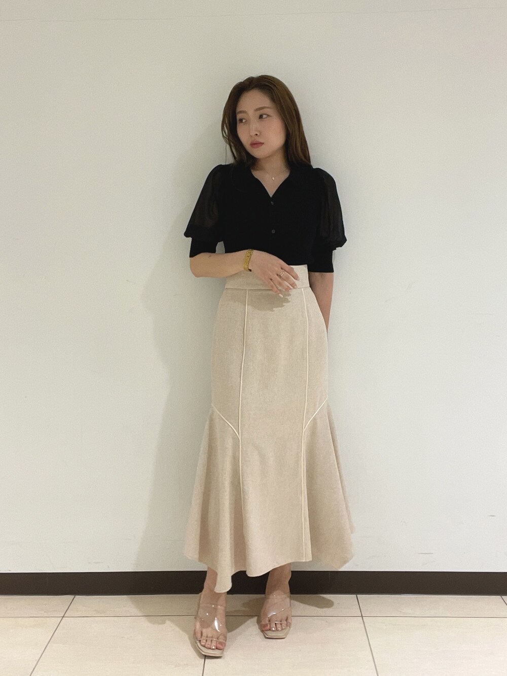 ブラック系のニット/セーター、ホワイト系のスカートを着用したレディースの夏コーディネートの6枚目の写真