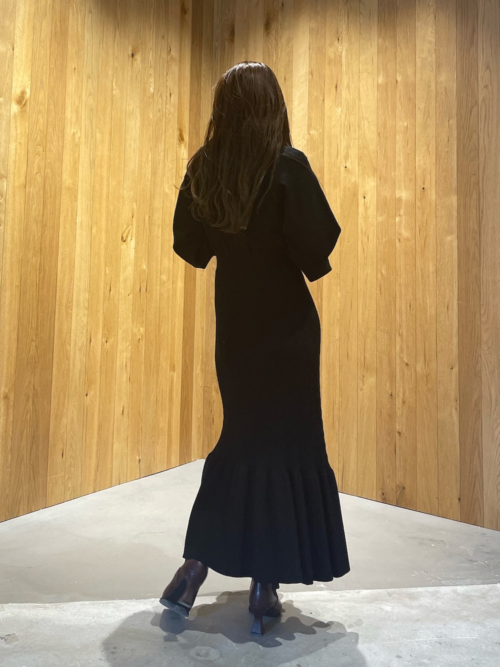 ブラウン系のブルゾン、レッド系のブーツ、ブラック系のワンピースを着用したレディースの秋コーディネートの7枚目の写真