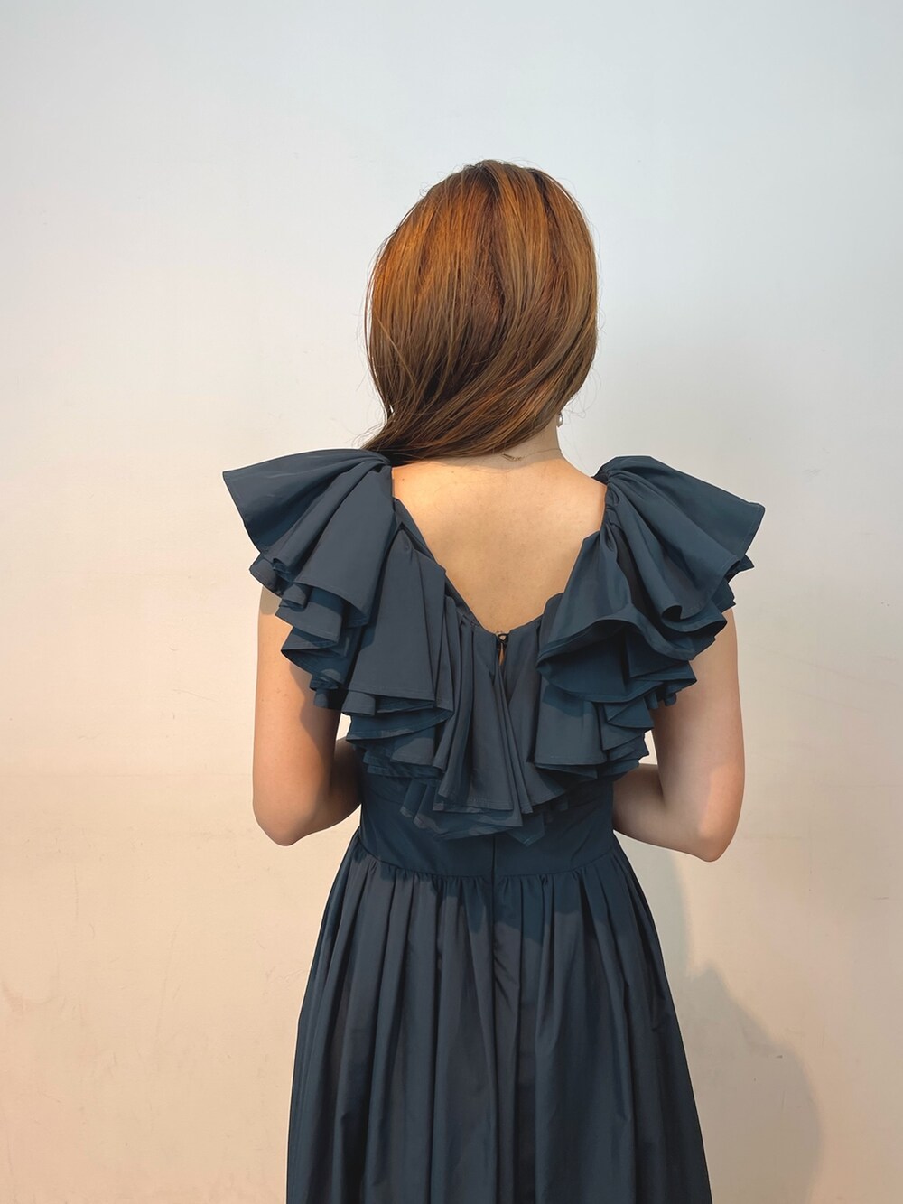 ベージュ系のパンプス、グリーン系のドレス、ゴールド系のピアス（両耳用）を着用したレディースの夏コーディネートの6枚目の写真