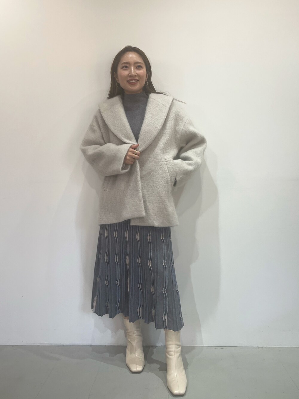 ホワイト系のブーツ、グレー系のワンピース、グレー系のその他アウターを着用したレディースの秋コーディネートの2枚目の写真