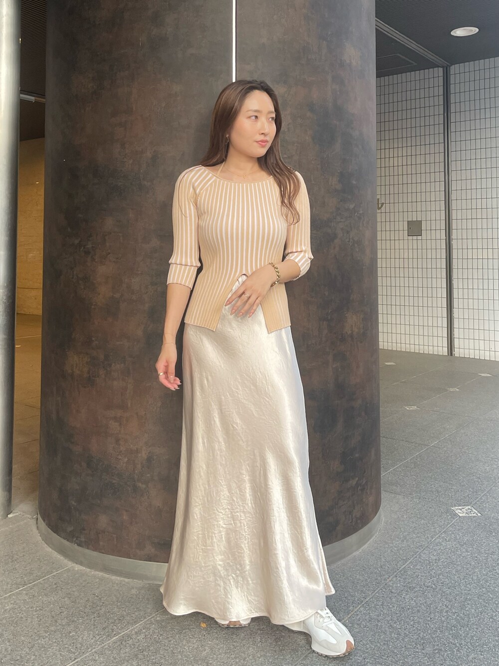 ベージュ系のニット/セーター、ホワイト系のスカートを着用したレディースの冬コーディネートの4枚目の写真