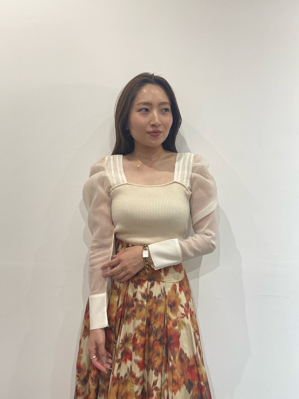 ベージュ系のブーツ、オレンジ系のスカート、ホワイト系のニット/セーターを着用したレディースの秋コーディネートの6枚目の写真