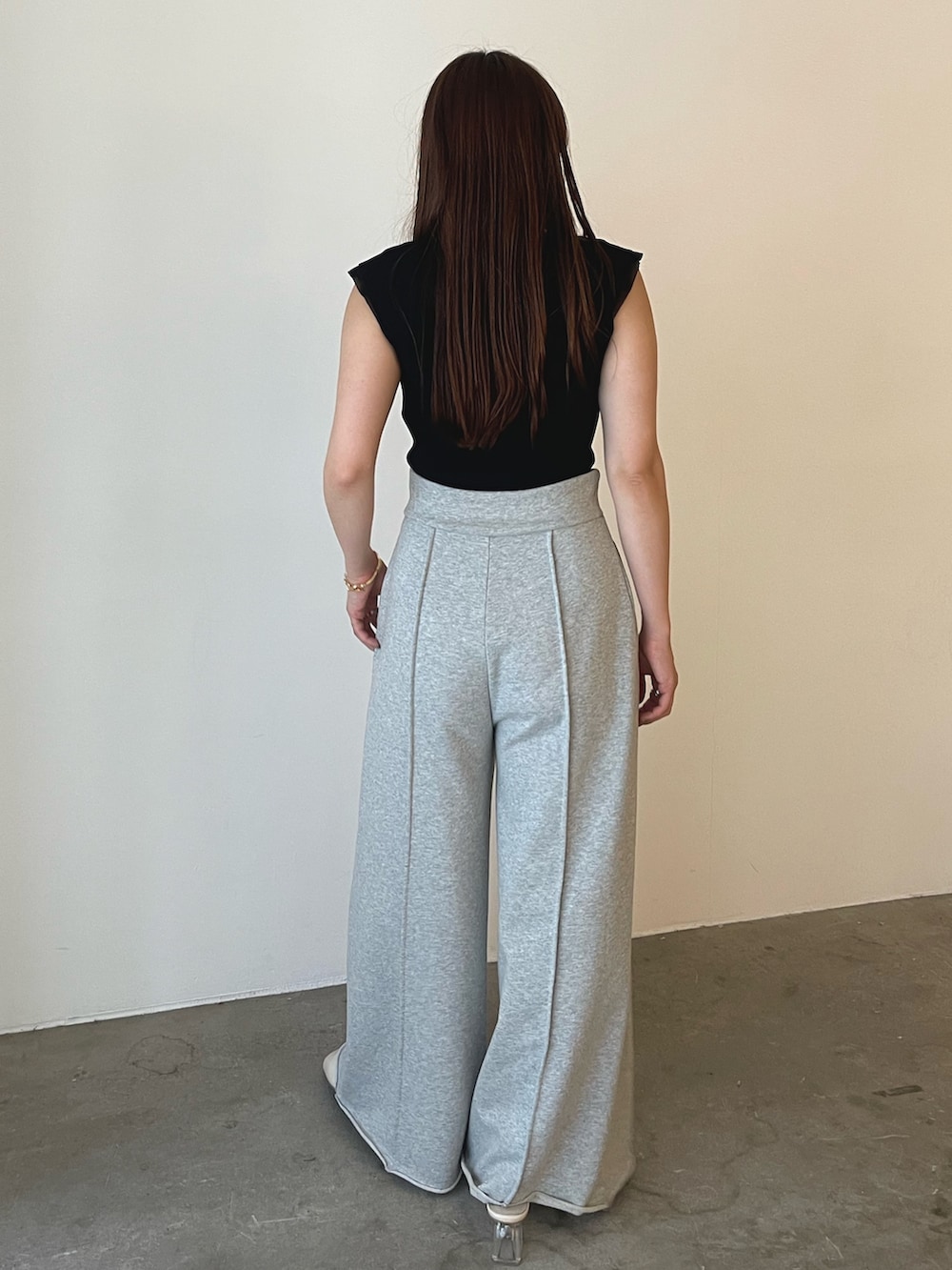 グレー系のスウェットパンツ、ホワイト系のサンダル、ブラック系のニット/セーターを着用したレディースの春コーディネートの6枚目の写真