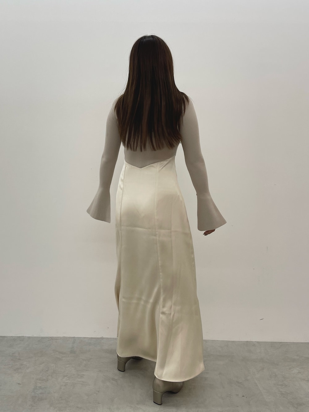 シルバー系のブーツ、ベージュ系のワンピースを着用したレディースの秋コーディネートの5枚目の写真