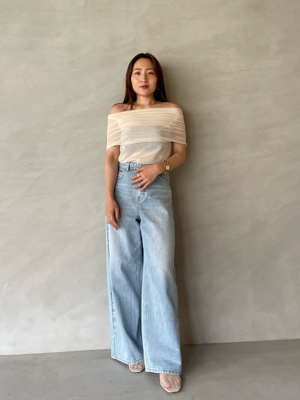 ブルー系のデニムパンツ、ホワイト系のTシャツ/カットソー、ホワイト系のサンダルを着用したレディースの夏コーディネートの3枚目の写真