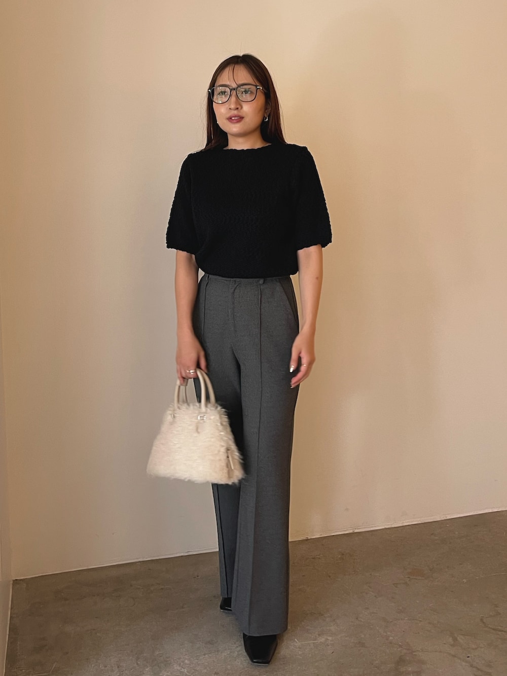 ホワイト系のボストンバッグ、ブラック系のブーツ、ブラック系のニット/セーターを着用したレディースの夏コーディネートの4枚目の写真