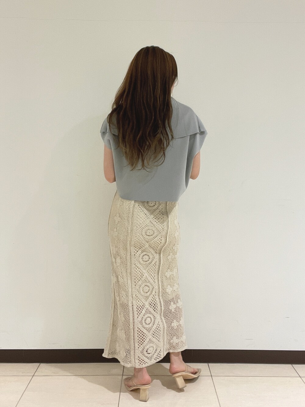 ブルー系のニット/セーター、ホワイト系のスカートを着用したレディースの春コーディネートの6枚目の写真