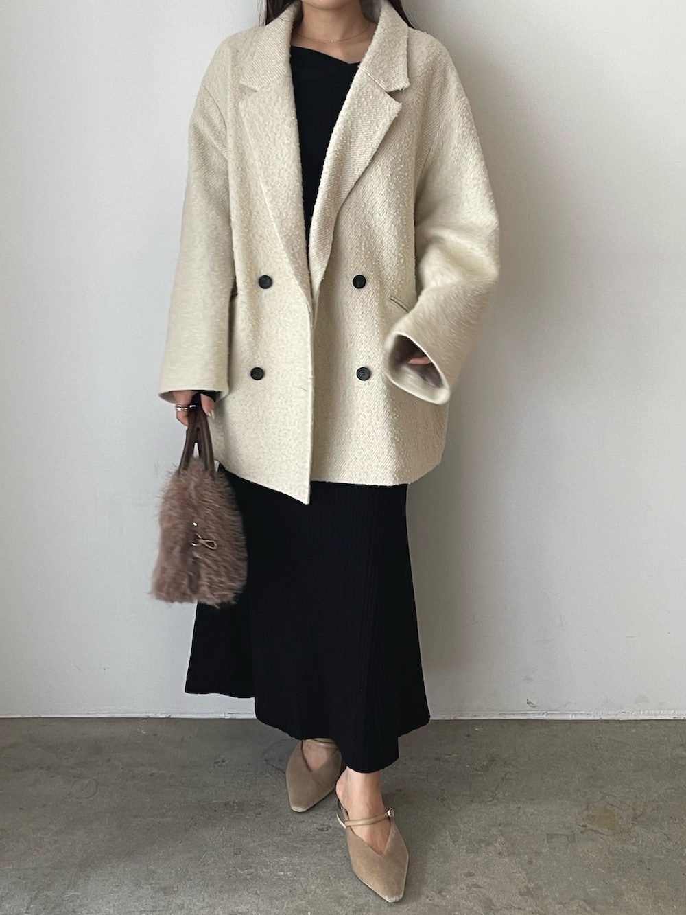 ブラック系のワンピース、ベージュ系のパンプス、ブラウン系のボストンバッグを着用したレディースの秋コーディネートの3枚目の写真