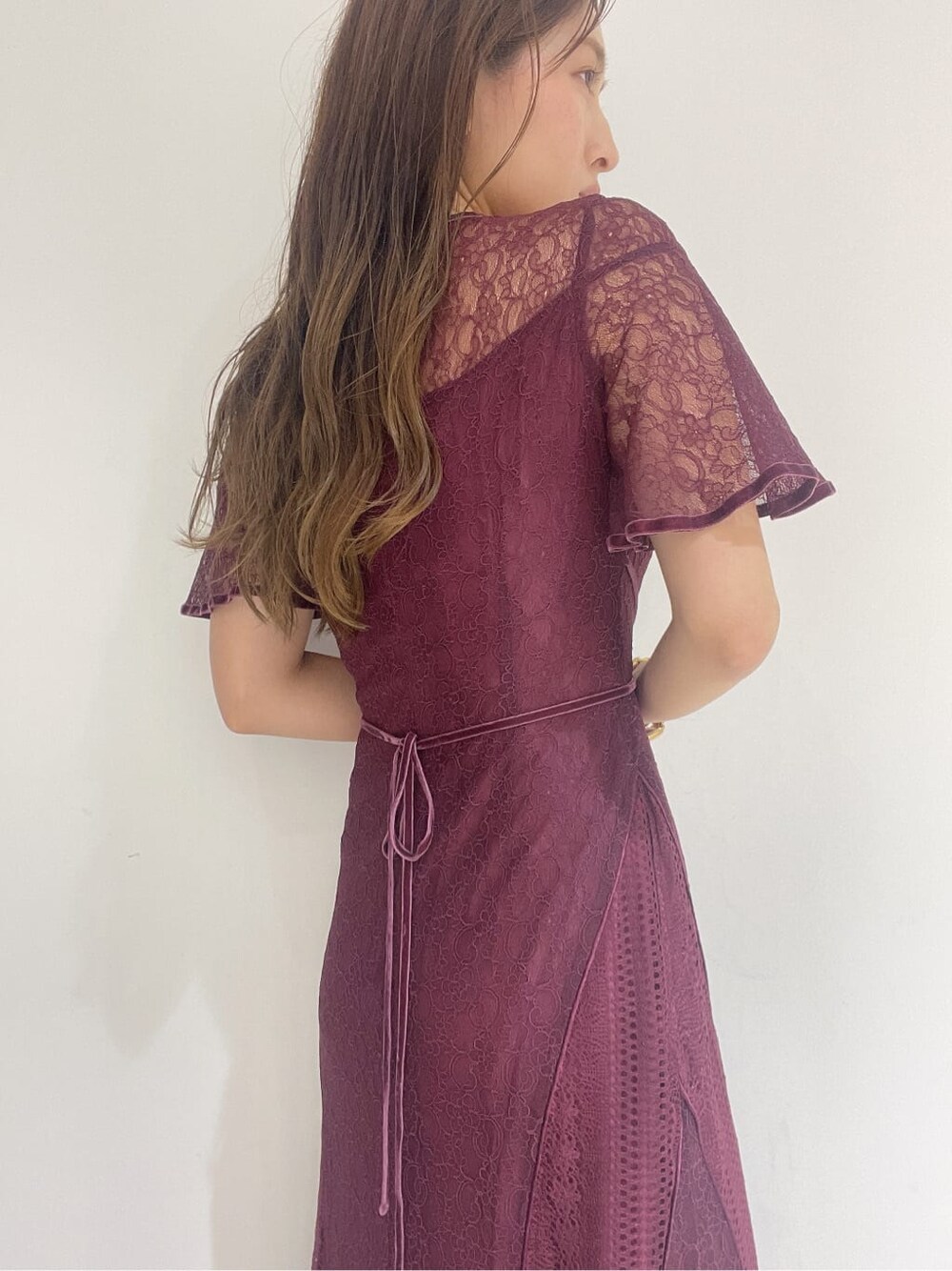 ゴールド系のクラッチバッグ、レッド系のドレス、ゴールド系のパンプスを着用したレディースの夏コーディネートの8枚目の写真