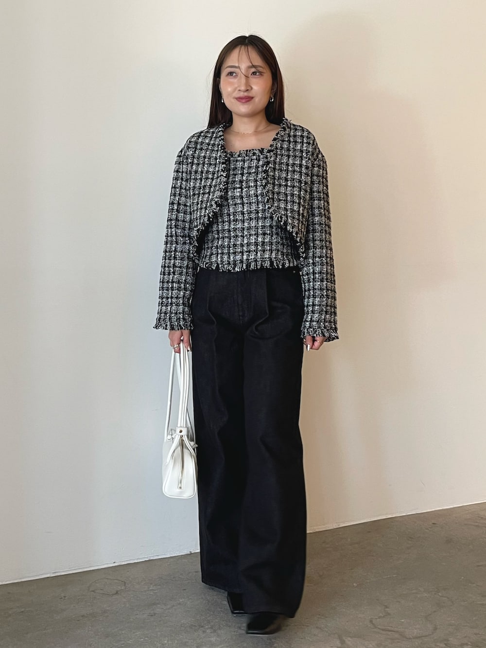 ホワイト系のショルダーバッグ、ブラック系のキャミソール、ブラック系のテーラードジャケットを着用したレディースの秋コーディネートの4枚目の写真