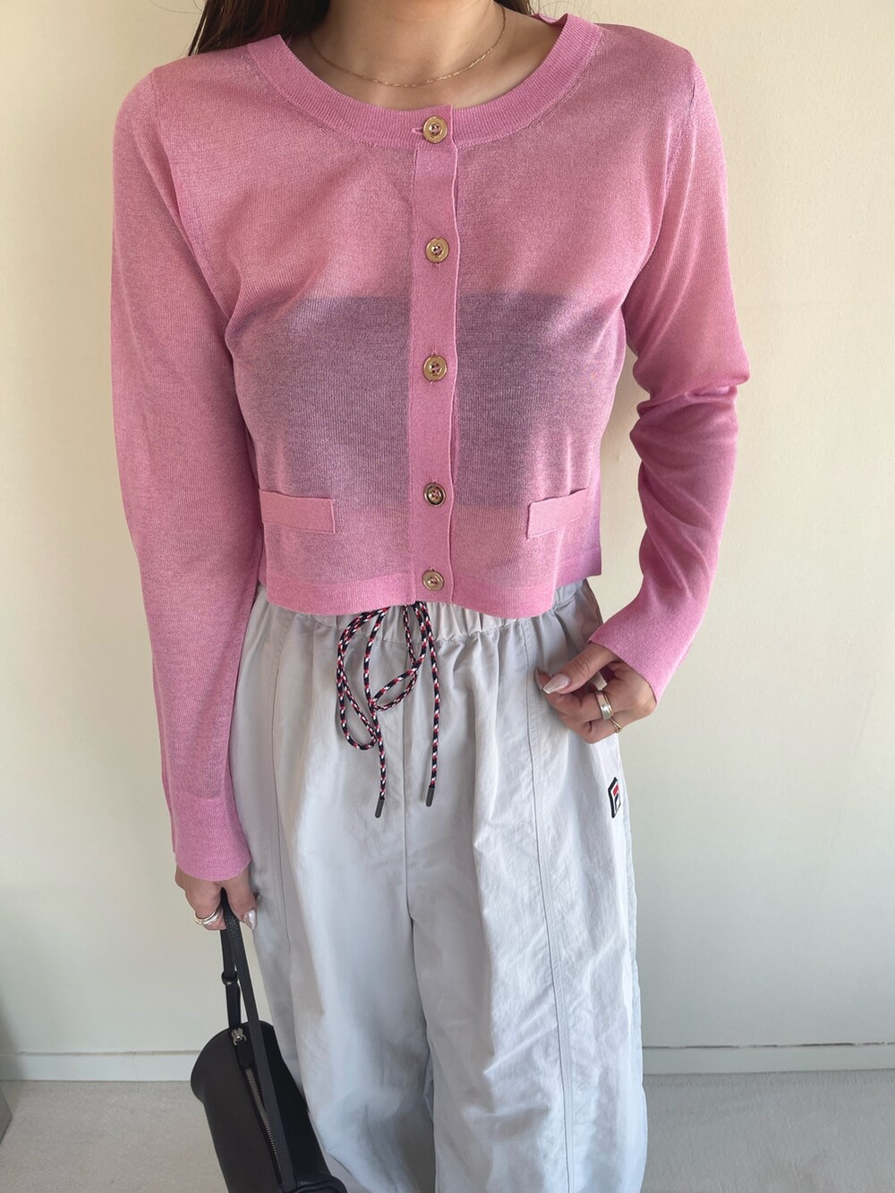 ピンク系のカーディガン/ボレロ、ベージュ系のその他パンツ、ブラック系のパンプスを着用したレディースの冬コーディネートの8枚目の写真