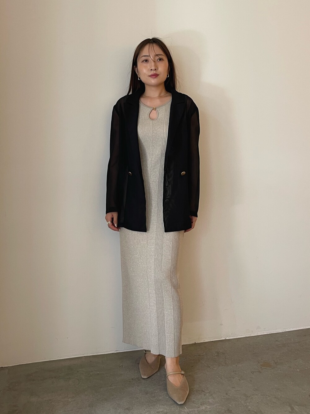 ベージュ系のワンピース、ブラック系のテーラードジャケット、ベージュ系のパンプスを着用したレディースの夏コーディネートの2枚目の写真